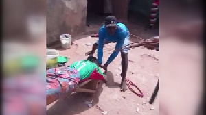 The girl is held down as another man administers the lashes