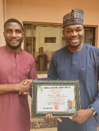 Dr. Razak Toure receiving the award from Abbas Badamasi