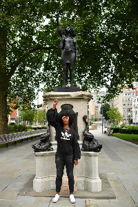 Black Lives Matter protestor Jen Reid poses for a photograph in front of a sculpture of herself