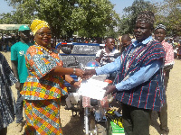 The DCE of Nadowli-Kaleo presenting the award to the overall best District Farmer