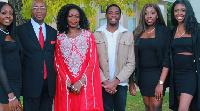 Evelyn Uba seen wearing red flanked by her husband and four children