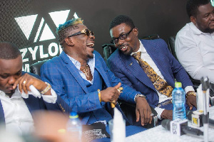 Shatta Wale shares a joke with CEO of Zylofon Media during the signing