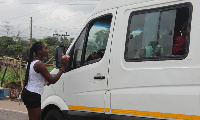 A DKT staff giving out a Kiss condom after interacting with a driver