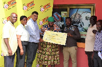 Officials from Happy FM present cheque to victim