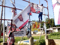 Pwoawuvi Joseph Weguri, showing one of the destroyed campaign banners to the press