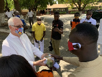 Reverend Agyenim Boateng presenting the cash to Father Campbell