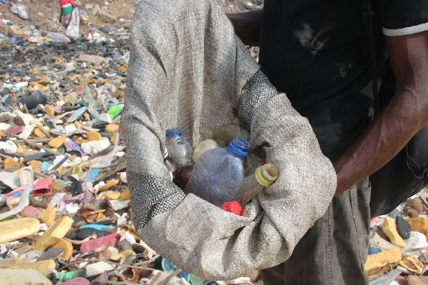 Kwesi Kyei collecting plastic bottles at the Jamestown Beach