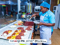 Faila dishing out food from one of the pots