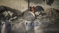 Chadian women pulverizing concrete