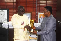 Isaac Adongo receiving the plaque