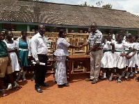 The Municipal Chief Executive (MCE) presenting dual desk  to the teachers