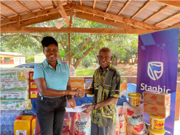 Abiana Nelson (left) presenting the items to the caretaker of the home, Mr. Adu Amoako