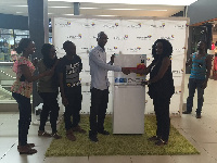 Event coordinator Ewurama Arhin (right) presents a refrigerator to Michael Michel