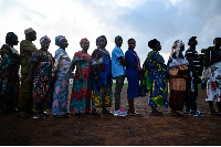 People wait to cast their votes for the national elections at a polling station in Freetown