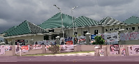 Walls of  Nzema Manle Complex plastered with various posters