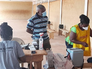 Techiman Municipal Director of Health Service, Dr Kusi and some health workers administering vaccine