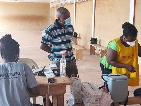 Techiman Municipal Director of Health Service, Dr Kusi and some health workers administering vaccine