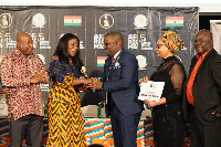 Mike Dada, Executive Producer of AFRIMA  presenting the trophy to Catherine Afeku