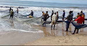 A photograph of fishermen performing their duties along the shores of small town in Ghana