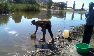 Hlotse Woman Draws Water From The Dam 768x461