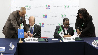 Dr Akinwumi Adesina (R) and Mr Philippe Scholtes signing the Memorandum of Understanding