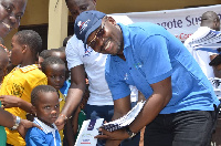 Mr. Houeto presenting books to some pupils