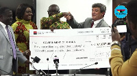 Minister for Lands and Natural Resources Kwaku Cheremeh taking the cheque from Kinross Chirano GM