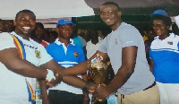 Michael Nkansah-Boateng presenting the trophy to Isaac Oteng, captain of Noka FC