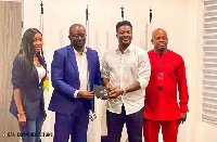 Asamoah Gyan presents an invitation to GFA boss