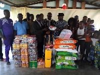 Nathan Gyasi in smock with his family members presenting the items to Rev Sakyi