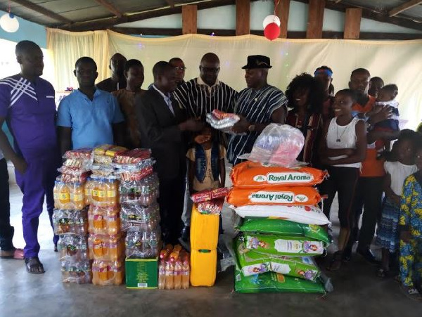 Nathan Gyasi in smock with his family members presenting the items to Rev Sakyi