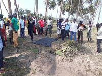 People gathered around the body that washed ashore