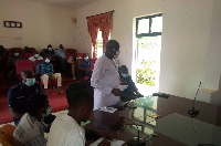 Drissa Ouattara standing and and interacting Mawirehene of Dormaa Traditional Council