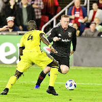 Jonathan Mensah takes on Wayne Rooney