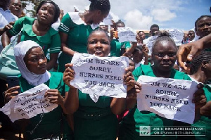 Some training nurses holding a paper with the inscription 'JM we are sorry'