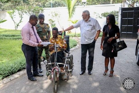 Former President Jerry John Rawlings with Emmanel Ofoe, the physically challenged street beggar