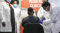 A healthcare worker administers a SINOVAC Covid-19 vaccine on a minor