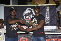 John Akada (left) presenting a trophy to one of the winners