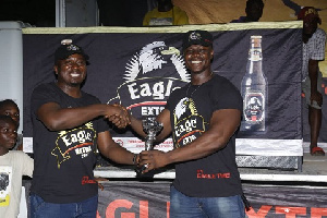 John Akada (left) presenting a trophy to one of the winners