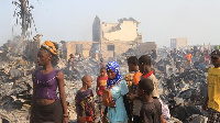 A man walks past metal sheeting' left at the aftermath of a large fire that broke out