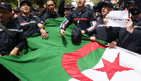 A photo of some Algerians with the national flag