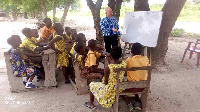 P1 pupils studying under trees along the highway