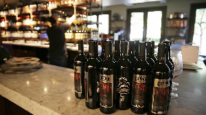 Bottles of Apocalypse Now Red Blend wine are seen on a tasting bar counter