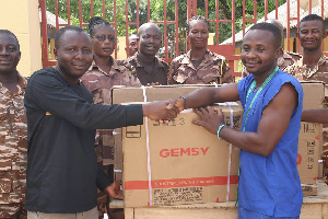 Ambassador Extraordinaire of Prisons, Ibrahim Oppong Kwarteng presenting the machine to Ishmael