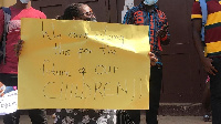 A parent holding a placard