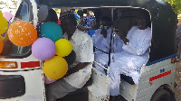 The couple seated in a tricycle after their traditional marriage