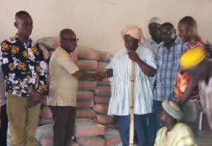 Dr Adam Mohammed Amin Anta presenting the items to the Regent and elders of Karaga