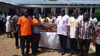 Ebenezer Okletey Terlabi [R] presenting the items to the school