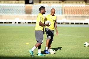 Asamoah Gyan standing with Andre Ayew