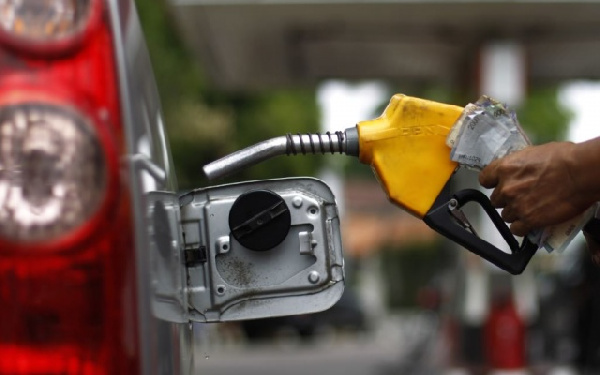 A fuel attendant serving a customer